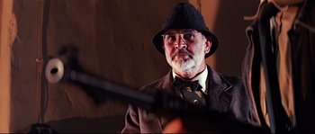 Movie still from “Indiana Jones and the Last Crusade” (1989), directed by Steven Spielberg – An older man wearing a hat and a bow tie; Close Up shot, Low angle