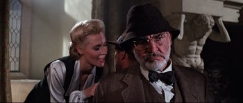 Movie still from “Indiana Jones and the Last Crusade” (1989), directed by Steven Spielberg – A man in a hat and a woman in a suit; Close Up shot, Low angle