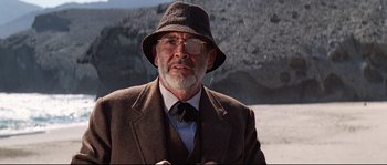 Movie still from “Indiana Jones and the Last Crusade” (1989), directed by Steven Spielberg – An older man wearing a suit and a hat; Close Up shot, Low angle