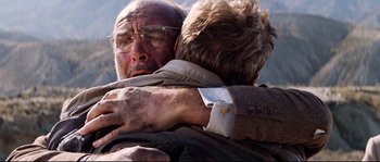 Movie still from “Indiana Jones and the Last Crusade” (1989), directed by Steven Spielberg – A man hugging another man with his arm around another man; Close Up shot, Low angle