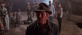 Movie still from “Indiana Jones and the Last Crusade” (1989), directed by Steven Spielberg – A person wearing a hat; Medium shot, Over the shoulder angle