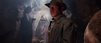 Movie still from “Indiana Jones and the Last Crusade” (1989), directed by Steven Spielberg – A person wearing a jacket and hat; Medium shot, Low angle