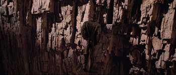Movie still from “Indiana Jones and the Last Crusade” (1989), directed by Steven Spielberg – A man standing on top of a rock wall; Wide shot, Overhead angle