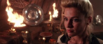Movie still from “Indiana Jones and the Last Crusade” (1989), directed by Steven Spielberg – A woman with blonde long hair and blue eyes looking to her left; Close Up shot, Over the shoulder angle