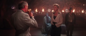 Movie still from “Indiana Jones and the Last Crusade” (1989), directed by Steven Spielberg – A man taking a picture of a woman and a monkey; Medium shot, Over the shoulder angle