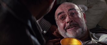 Movie still from “Indiana Jones and the Last Crusade” (1989), directed by Steven Spielberg – An older man with glasses is looking at the camera; Close Up shot, Low angle