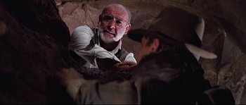 Movie still from “Indiana Jones and the Last Crusade” (1989), directed by Steven Spielberg – An older man with a beard talking to an older man in a cowboy hat; Close Up shot, Low angle