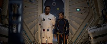 Movie still from “Lost in Space” (2018), created by Irwin Allen – A man and a woman standing next to each other; Medium shot, Over the shoulder angle