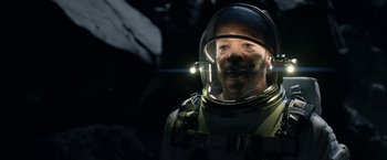 Movie still from “Lost in Space” (2018), created by Irwin Allen – A man in a space suit with a helmet on his head; Close Up shot, Overhead angle