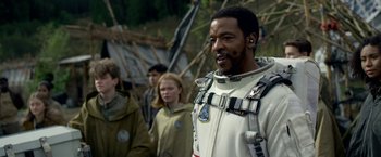 Movie still from “Lost in Space” (2018), created by Irwin Allen – A group of people standing next to each other; Close Up shot, Over the shoulder angle