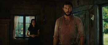 Movie still from “Inglourious Basterds” (2009), directed by Quentin Tarantino – A man standing next to a woman in a room; Medium shot, Over the shoulder angle