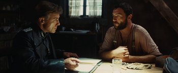 Movie still from “Inglourious Basterds” (2009), directed by Quentin Tarantino – Two men sitting at a table talking to each other; Medium shot, Over the shoulder angle