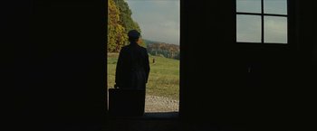 Movie still from “Inglourious Basterds” (2009), directed by Quentin Tarantino – A man standing in front of an open door with a briefcase; Extreme Wide shot, Over the shoulder angle