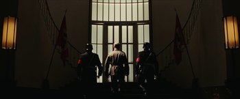 Movie still from “Inglourious Basterds” (2009), directed by Quentin Tarantino – A group of men standing in front of an open door; Wide shot, Low angle