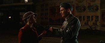Movie still from “Inglourious Basterds” (2009), directed by Quentin Tarantino – A man in a military uniform is holding a knife; Medium shot, Over the shoulder angle