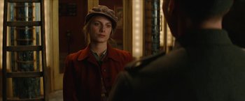 Movie still from “Inglourious Basterds” (2009), directed by Quentin Tarantino – A woman wearing a hat and a red jacket; Close Up shot, Over the shoulder angle