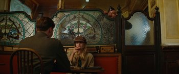Movie still from “Inglourious Basterds” (2009), directed by Quentin Tarantino – A woman sitting in front of a stained - glass window; Medium shot, Over the shoulder angle