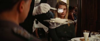 Movie still from “Inglourious Basterds” (2009), directed by Quentin Tarantino – A woman sitting in front of a tray of food; Medium shot, Over the shoulder angle