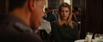 Movie still from “Inglourious Basterds” (2009), directed by Quentin Tarantino – A woman sitting in front of a man at a table; Close Up shot, Over the shoulder angle