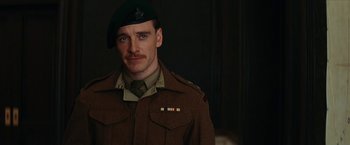 Movie still from “Inglourious Basterds” (2009), directed by Quentin Tarantino – A man in a military uniform with a beret; Medium shot, Over the shoulder angle