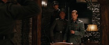 Movie still from “Inglourious Basterds” (2009), directed by Quentin Tarantino – A group of men standing next to each other in a room; Medium shot, Over the shoulder angle