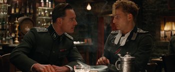 Movie still from “Inglourious Basterds” (2009), directed by Quentin Tarantino – Two men in uniforms are sitting at a table; Close Up shot, Over the shoulder angle