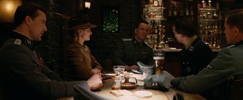 Movie still from “Inglourious Basterds” (2009), directed by Quentin Tarantino – A man and a woman sitting at a table with drinks; Medium shot, Over the shoulder angle