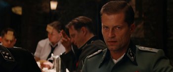 Movie still from “Inglourious Basterds” (2009), directed by Quentin Tarantino – A group of people sitting at a table; Close Up shot, Over the shoulder angle