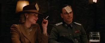 Movie still from “Inglourious Basterds” (2009), directed by Quentin Tarantino – A man and a woman sitting next to each other; Medium shot, High angle