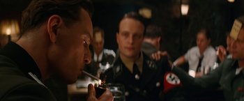 Movie still from “Inglourious Basterds” (2009), directed by Quentin Tarantino – A group of men in uniforms smoking a cigarette; Close Up shot, Over the shoulder angle