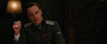 Movie still from “Inglourious Basterds” (2009), directed by Quentin Tarantino – A man in a uniform is sitting in a chair; Close Up shot, Over the shoulder angle