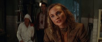 Movie still from “Inglourious Basterds” (2009), directed by Quentin Tarantino – A young woman with blonde curly hair wearing a brown jacket; Close Up shot, Over the shoulder angle