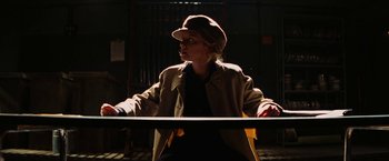 Movie still from “Inglourious Basterds” (2009), directed by Quentin Tarantino – A woman wearing a hat is standing in the dark; Medium shot, Low angle