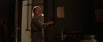 Movie still from “Inglourious Basterds” (2009), directed by Quentin Tarantino – A woman standing in front of a wall with bottles; Medium shot, Over the shoulder angle
