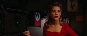 Movie still from “Inglourious Basterds” (2009), directed by Quentin Tarantino – A woman in a red dress looking at the camera; Close Up shot, Over the shoulder angle