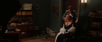 Movie still from “Inglourious Basterds” (2009), directed by Quentin Tarantino – A woman sitting in a chair with a man in a room; Medium shot, Over the shoulder angle