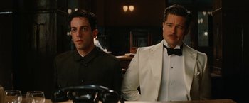 Movie still from “Inglourious Basterds” (2009), directed by Quentin Tarantino – Two men sitting at a table in front of each other wearing suits; Medium shot, Low angle