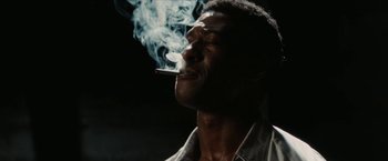 Movie still from “Inglourious Basterds” (2009), directed by Quentin Tarantino – A man smoking a cigarette while wearing a white shirt; Close Up shot, Low angle