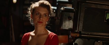 Movie still from “Inglourious Basterds” (2009), directed by Quentin Tarantino – A woman in a red dress standing in front of a camera; Close Up shot, Low angle