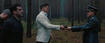 Movie still from “Inglourious Basterds” (2009), directed by Quentin Tarantino – A man in a white jacket is handing a key to another man; Medium shot, Over the shoulder angle