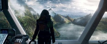 Movie still from “Lost in Space” (2018), created by Irwin Allen – A woman standing in front of a large painting of mountains; Extreme Wide shot, High angle