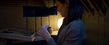 Movie still from “Lost in Space” (2018), created by Irwin Allen – A woman is holding a pair of playing cards in her hands; Close Up shot, High angle