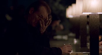 Movie still from “Lost in Translation” (2003), directed by Sofia Coppola – A man sitting at a table with a cell phone in front of him; Close Up shot, Over the shoulder angle