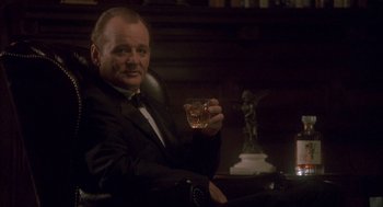 Movie still from “Lost in Translation” (2003), directed by Sofia Coppola – A man in a black suit holding a glass of whiskey; Medium shot, Low angle