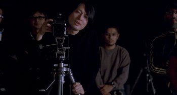 Movie still from “Lost in Translation” (2003), directed by Sofia Coppola – A man standing in front of two other men; Medium shot, Low angle