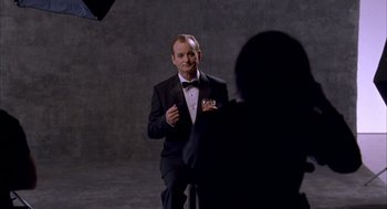 Movie still from “Lost in Translation” (2003), directed by Sofia Coppola – A man in a tuxedo is being interviewed by a camera; Medium shot, Over the shoulder angle