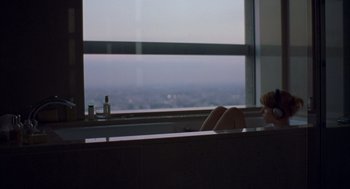 Movie still from “Lost in Translation” (2003), directed by Sofia Coppola – A woman sitting in a bath tub in front of a large window; Wide shot, High angle