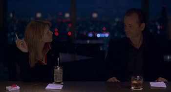 Movie still from “Lost in Translation” (2003), directed by Sofia Coppola – A man and a woman are sitting at a table; Medium shot, Over the shoulder angle