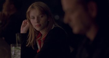 Movie still from “Lost in Translation” (2003), directed by Sofia Coppola – A young woman in a red and black shirt is looking at the camera; Close Up shot, Over the shoulder angle
