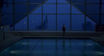 Movie still from “Lost in Translation” (2003), directed by Sofia Coppola – A woman standing in front of a window at night; Extreme Wide shot, High angle